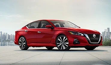 2023 Nissan Altima in red with city in background illustrating last year's 2022 model in Neil Huffman Nissan of Frankfort in Frankfort KY