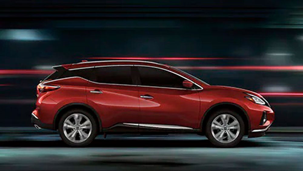 2023 Nissan Murano shown in profile driving down a street at night illustrating performance. | Neil Huffman Nissan of Frankfort in Frankfort KY